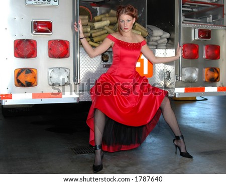 Pretty woman in red dress and fire truck