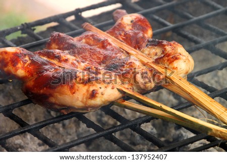 Grilled chicken over gridiron and low heat from natural charcoal