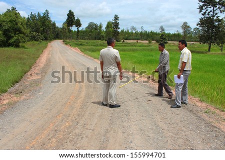 MAHASARAKHAM, THAILAND - SEPTEMBER 16 : Unidentified men survey local road for public  construction on September 16, 2013 in Mahasarakham, Thailand.