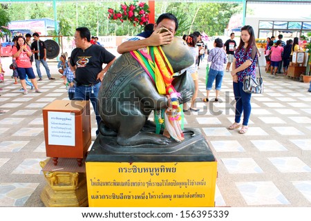 NAKORN NAYOK, THAILAND - SEPTEMBER 22 : Unidentified man whispers in Celestial ear rat statue at Ganesha Garden on September 22, 2013 in Nakorn Nayok, Thailand.