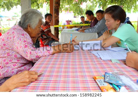 MAHASARAKHAM - SEPTEMBER 14 : Unidentified old woman goes to vote for village headman election at Tha Rae Pattana on September 14, 2013 in Muang, Mahasarakham, Thailand.
