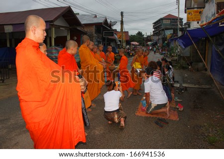 VANG VIENG, LAO P.D.R. - AUGUST 25 : Monks ask for alms at traditional morning market on August 25, 2013 in Vang Vieng, Lao P.D.R.