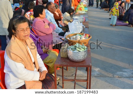 PAYAKKAPHUMPHISAI, MAHASARAKHAM - JANUARY 1 : Thai people prepare to give food offerings to a Buddhist monk at city hall plaza on January 1, 2014 in Payakkaphumphisai, Mahasarakham, Thailand.