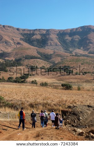 Group of people walking towards a mountain range at Dunblane, KZN, South Africa