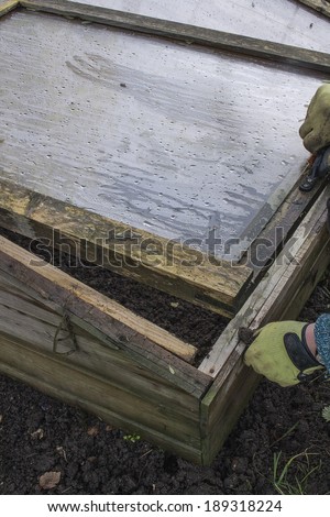 COLD FRAME WARMING UP THE SOIL IN A VEGETABLE PLOT