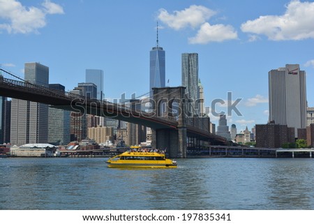 NEW YORK CITY, USA - June 6, 2014: New York Water Taxi cruising in the East River with the Lower Manhattan skyline and Brooklyn Bridge in the background.
