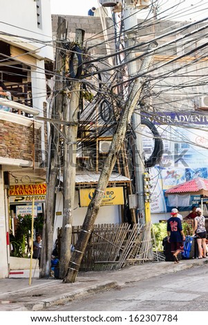 BORACAY, PHILIPPINES - NOVEMBER 9 2013: A power line and pole ls bent and broken following the passage of Typhoon Haiyan.  Typhoon Haiyan caused widespread disruption to infrastructure in the area