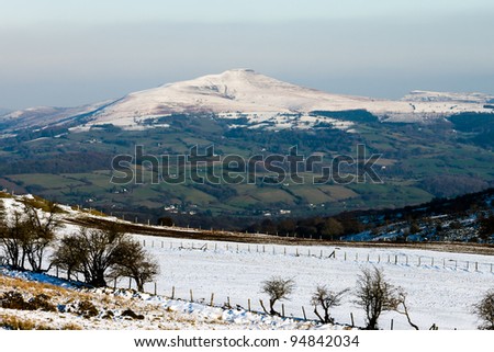 Snow covered farmers fields with a mountain and clear snowline in the background