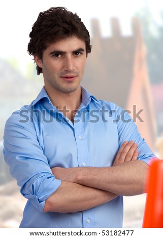 Young, confident foreman with rolled-up sleeves at construction site, ready for action