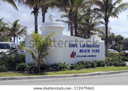 FORT LAUDERDALE, FLORIDA - APRIL 6, 2013: Closeup of Ft Lauderdale Beach Park sign with palm trees and autos in the background. Location is at 1100 Seabreeze Boulevard and is open 5 AM to midnight.
