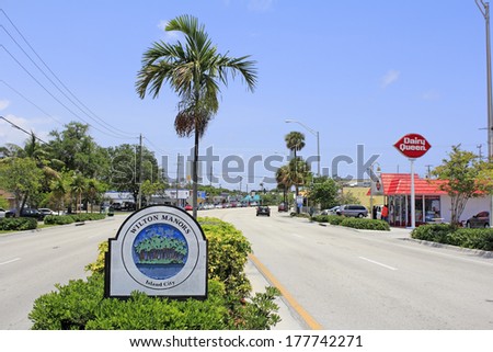 WILTON MANORS, FLORIDA - MAY 11, 2013: Sign that says Wilton Manors and Island City with palm trees on an island graphic in the median of Wilton Drive in this urban city of 11,9995 in 2012.