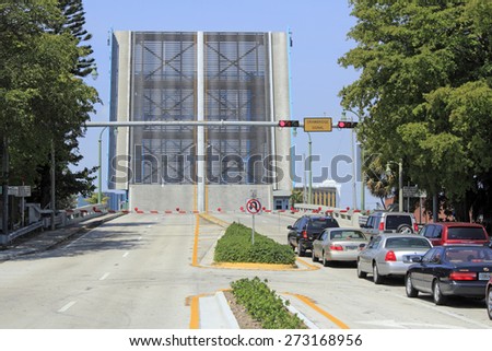 LAUDERDALE-BY-THE-SEA, FL, USA - APRIL 7, 2014: A drawbridge is raised straight up and cars wait patiently on the east side of the Intracoastal Waterway on Commercial Boulevard on a sunny day.