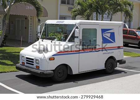 FORT-LAUDERDALE, FL, USA - JUNE 5, 2014: One deliver mail parked in front of a residential condominium on a sunny day. USPS Mail delivery truck parked on a neighborhood street.