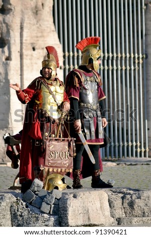 ROME, ITALY - DECEMBER 20: Unidentified street performers dressed like Roman soldiers offer photo sessions to tourists in front of Colosseum in Rome, Italy on December 20, 2011.