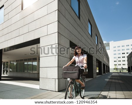mid adult caucasian business woman commuting to office by bike and smiling