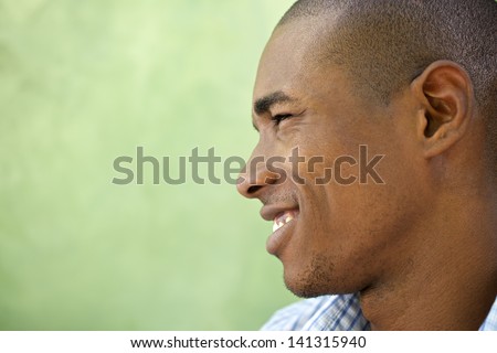 Portrait of happy young african american man looking away and smiling. Head and shoulders, copy space