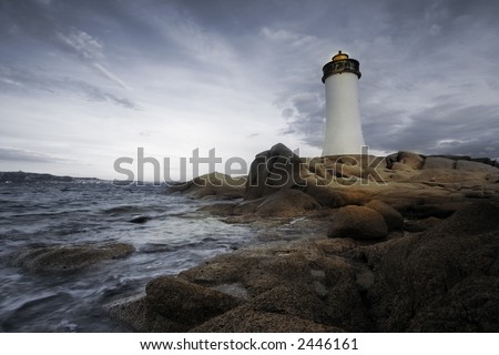 lighthouse seen from a tiny beach in Sardinia.