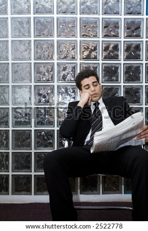 hard worker: business man sitting in a waiting room and checking stocks