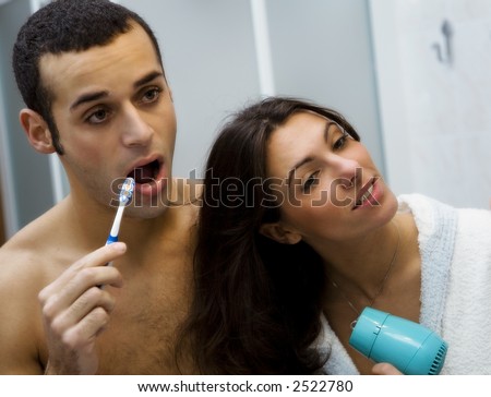 morning routine: the guy brushing his teeth and the girl hairdrying