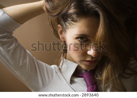 women at work: irritated businesswoman fixing her tie