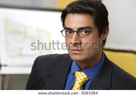 work place: successful businessman smiling and staring at the camera