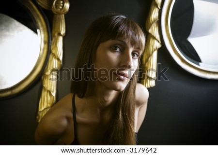 posh girl posing between two old mirrors