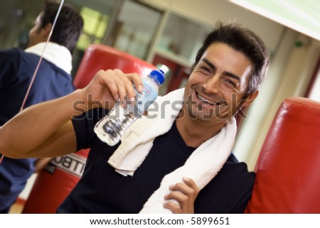 health club: athlete relaxing and drinking some water
