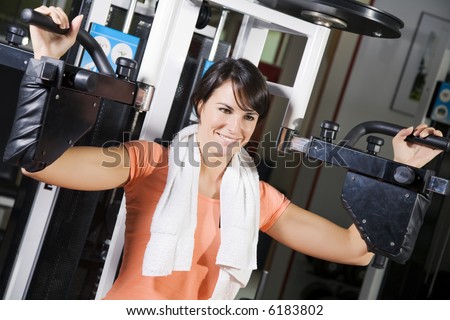 health club: girl in a gym doing weight lifting