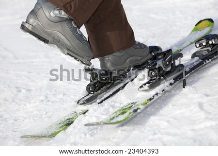 Low section view of woman unfastening her ski boots.