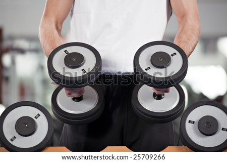 close up of man holding weight in gym