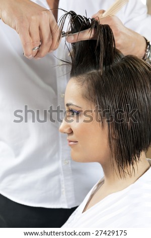 portrait of young woman having her hair being cut