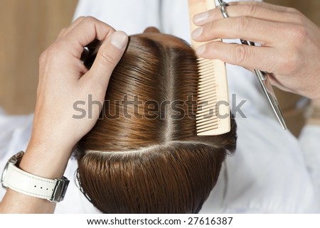 high angle view of hairdresser using comb