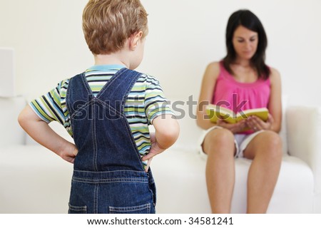bored boy looking at mom with hands on hips
