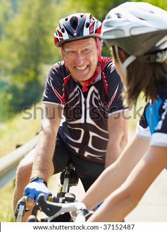 Senior man and young woman on road bike