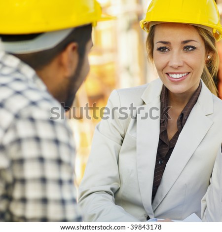 latin american construction worker and female architect talking.