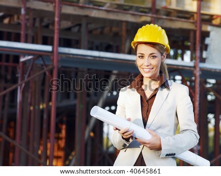 mid adult architect holding blueprints and smiling. Copy space
