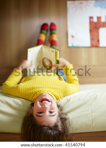 girl lying on bed and reading book