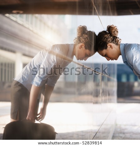 mid adult italian business woman banging her head against a wall outside office building. Square shape, copy space