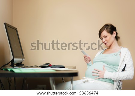italian 6 months pregnant woman watching ultrasound pictures of her baby on desktop computer at home. Horizontal shape, side view, copy space