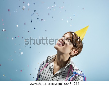 caucasian woman looking at confetti in the air. Horizontal shape, side view, head and shoulders, copy space