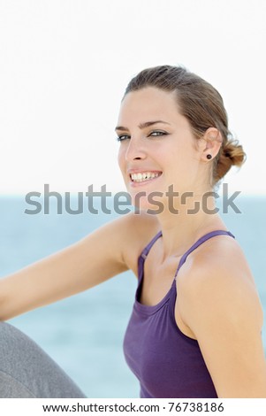 portrait of young caucasian woman looking at camera near the sea. Horizontal shape, waist up, copy space