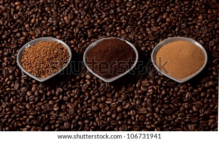 Three types of coffee in small cups on coffee beans