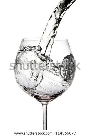 Pouring water into glass isolated on white (splash of water)