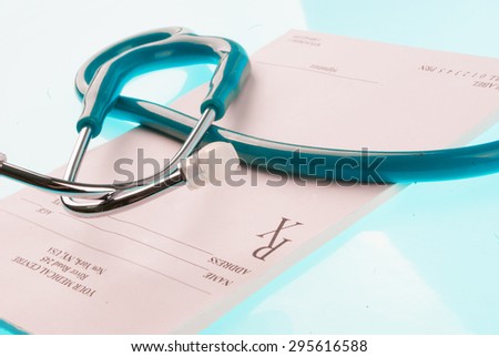 Empty medical prescription with a stethoscope on blue reflective background