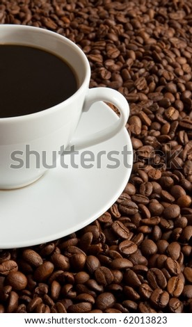 Cup of coffee on coffee beans with shallow depth of field