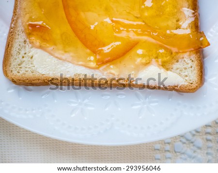 Toast with orange marmalade on the white fancy plate
