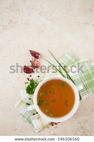 Bone Broth in Small Soup Bowl Served with Fresh Herbs, Garlic and Spices Extra Space for Text