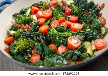 Broccolini, Cherry Tomatoes, Italian Kale, and Onions Sauteed in Skillet for Healthy Meal