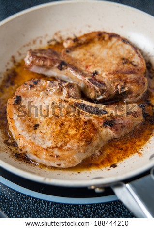 Two Fried Pork Chops in Skillet