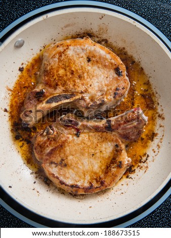 Two Fried Pork Chops in Skillet
